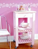 Pink food trolley against pink wall with white border