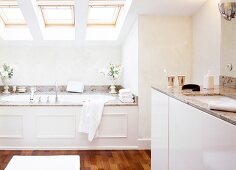 White bathroom built-in bathtub and three skylights