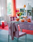 Orange tea set on table with purple tablecloth in dining room