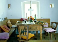 Country style laid table with chairs in front of window in dining room