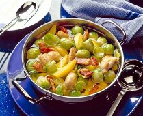 Brussels sprouts and potato stew with bacon and chicken breast fillet in a casserole