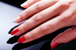 Close-up of woman applying red base coat her fingernails, step 3