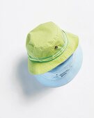Close-up of green and blue hat on white background