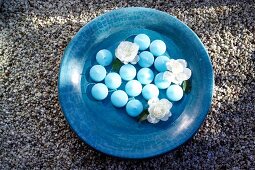 Blue floating candles and white rose in blue bowl