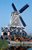 View of windmill on the lake against blue sky