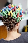 Rear view of woman wearing multi coloured screwed papilotten in hair, close-up