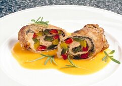 Close-up of pork roulades with peppers and rosemary on plate