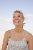 Happy woman wearing floral patterned top looking up and laughing