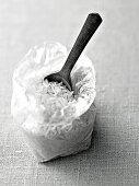 Jasmine rice in plastic bag with spoon in it, black and white