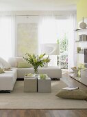Living room with light green painted wall, white sofa and cushion