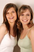 Portrait of two beautiful woman standing side by side, smiling