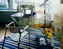 Schreibtisch mit Glasplatte und Metallstuhl, Teppich blau gestreift