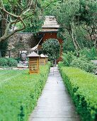 Gartenweg, Buchsbaumhecke, Bäume, Holzleuchte, asiatischer Garten