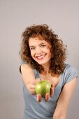 Woman holding apple in hand and laughing