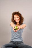 Woman holding apple in hand and laughing