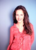 Portrait of beautiful woman wearing red blouse with ruffles standing, smiling