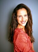 Portrait of beautiful woman wearing red blouse with ruffles standing, smiling widely