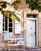 Facade of house with white doors and windows and bench