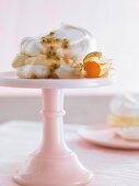 Meringue with passion fruit cream on a cake stand