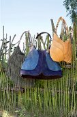 Three shoulder bags hanging on wicker fence