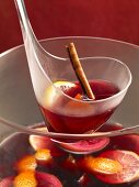 Feuerzangenbowle (mulled wine with added rum and sugar) with a cinnamon stick, lemons and oranges