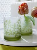 Close-up of two green satin glasses with flowers