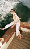 Woman in sunglasses in white clothes on a boat