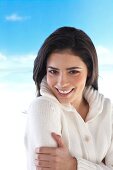 Portrait of attractive woman with long brown hair wearing cardigan, smiling