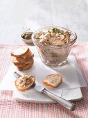 Smoked mackerel pate in glass bowl with slices of white bread
