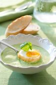 Herb soup with fried egg in bowl