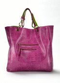 Close-up of pink handbag made of snakeskin on white background