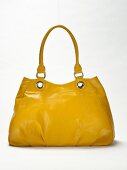 Close-up of yellow leather handbag on white background