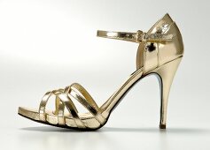 Close-up of golden stiletto heel on white background