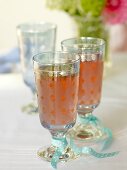 Two rhubarb juice in crystal glasses tied with turquoise ribbon