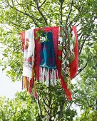 Fringed colourful scarves hanging on tree