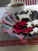 Red felt stars with star shaped cinnamon biscuits and cup of tea on zinc plate