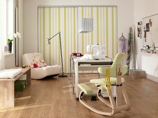 Sewing machine on table in front of fitted wardrobe with striped door on sewing room