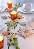 Garland of star-shaped biscuits and ribbon on candlelit table