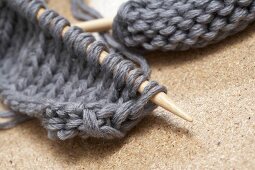 Close-up of knitting needle in gray wool