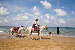 Man riding horses on beach while on vacation in Kilyos, Istanbul, Turkey