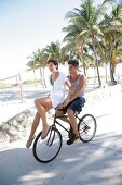 Paar hat Spaß auf einem Rad sie sitzt auf Lenker