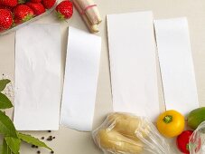 Four blank pieces of paper surrounded by fruit, vegetables and spices