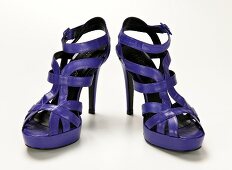 Strappy purple stilettos with platform on white background