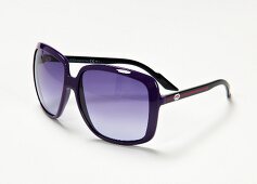 Close-up of purple-black sunglasses on white background