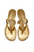 Close-up of golden colour toe sandals on white background