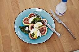 Mozzarella with figs and basil on plate