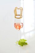 Rosé-Weinglas mit Krönchen auf 