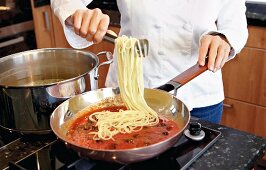 Spaghetti werden mit der Sauce vermengt, Step