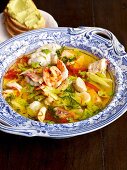 Classic bouillabaisse with saffron in serving bowl and garlic bread