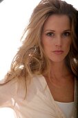 Portrait of beautiful green eyed blonde woman wearing beige shirt, close-up